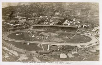 Aerial shot of a grand stand and in an amusement park. B & W.