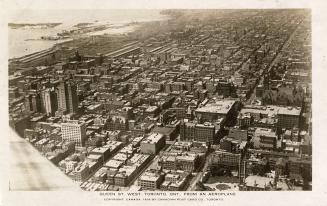 Aerial shot of a large city with tall buildings. Black and white.