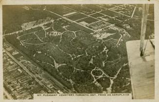 Aerial shot of a wooded area in a city. Black and white.