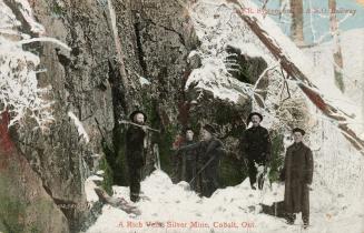 Five men standing in a stope in the winter time.