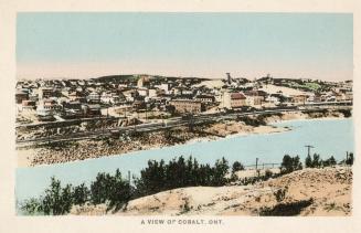 Colorized picture of a small mining town beside a lake.