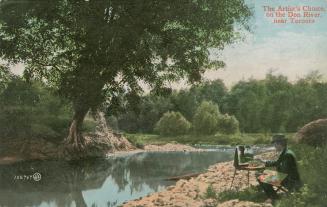 Colorized photograph of an artist sitting on a stool by a river painting the scene on a canvass ...