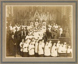 A photograph of a church choir comprised of adult men and boys, wearing robes and standing in f ...