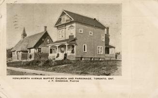 Picture of a church building and parsonage with people sitting on the verandah and steps. 