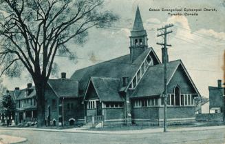 Picture of a church building on corner with large tree on left. 
