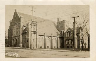 Picture of large stone church on street corner. 