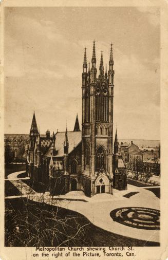 Picture of large church with steeple with surrounding gardens. 