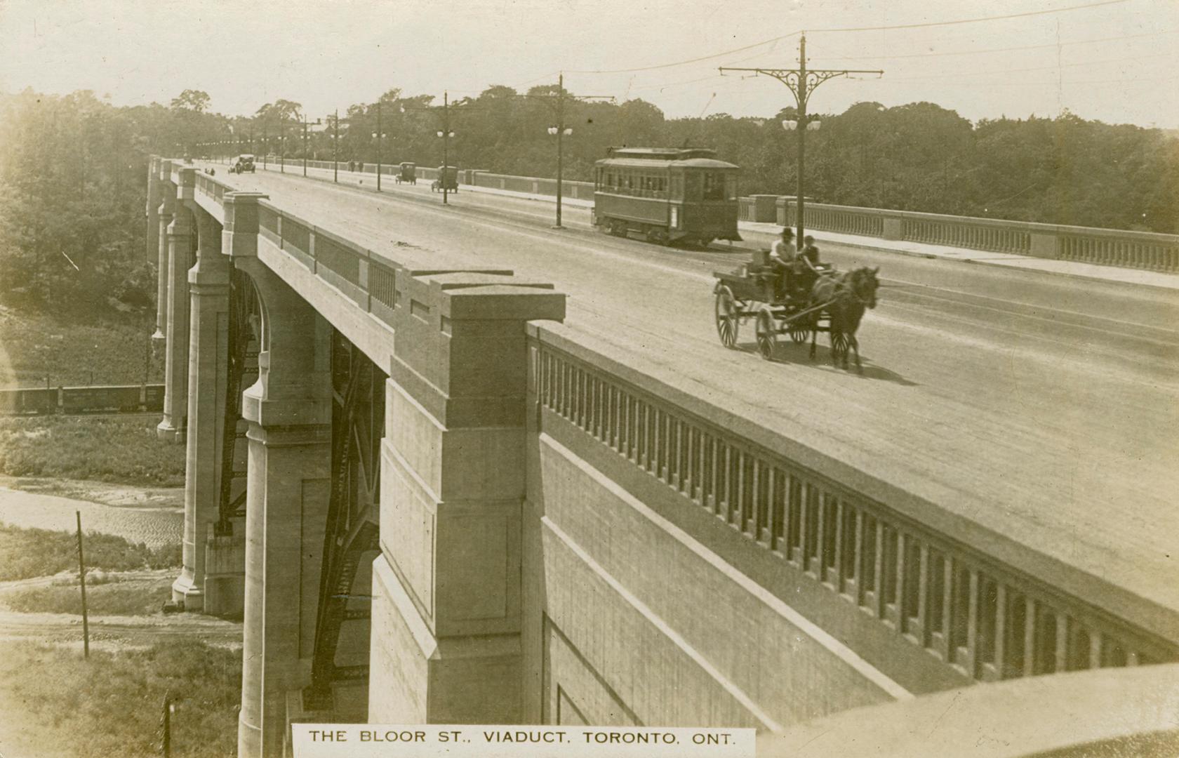 Black and white photograph of a street car and a horse and wagon driving across a bridge.