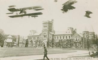 Black and white photograph of three airplanes flying over a large academic building.