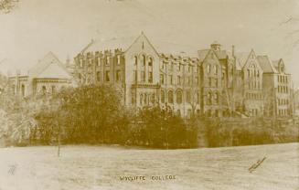 Black and white photograph of a very large collegiate building.