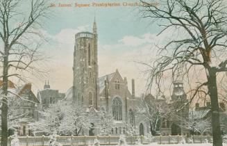 Snowy street scene showing large church and other buildings. 