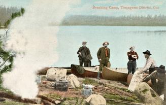 Colorized photograph of five men packing up their canoes ready to leave a bush camp.