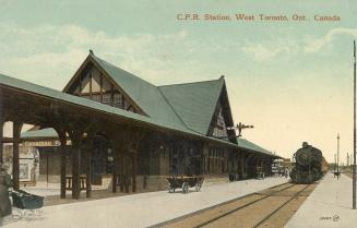 Picture of railway station with tracks in foreground and locomotive. 