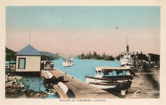 Colorized photograph of dock with boats on lake in the wilderness. 