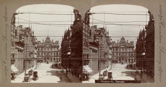 A stereographic photograph of a city street, with buildings on both sides of the street and ano ...