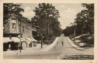 Picture of street going up a hill with building on left. 