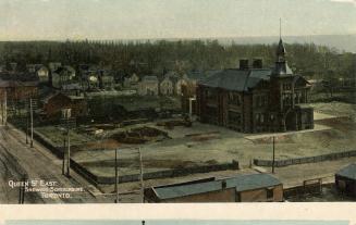 Picture of large school house with tower and surrounding streets. 
