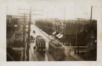 Black and white postcard of Dundas St. E with two streetcars and tracks. The back is filled wit ...