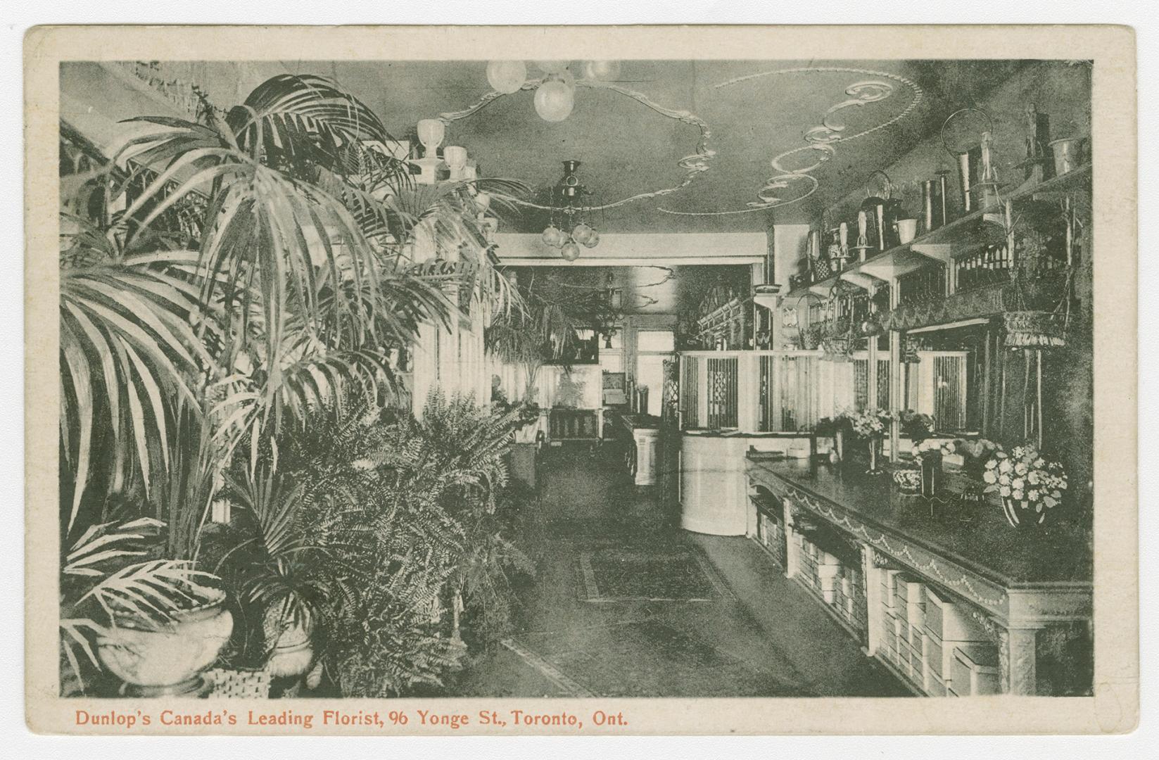 Black and white photograph of an interior of a flower shop.