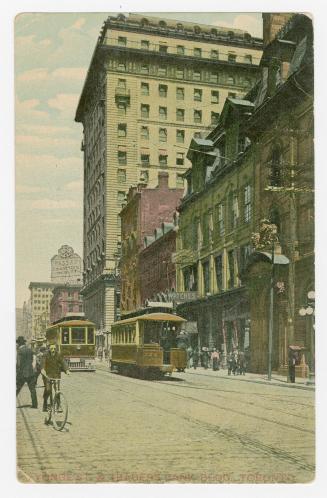 Colorized photograph of a busy downtown street in a city with a large skyscraper on the right h ...