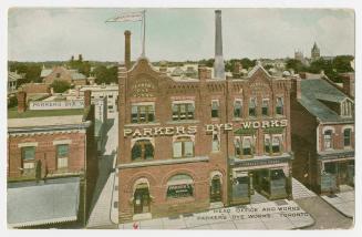 Colorized photograph of a large factory and office building.