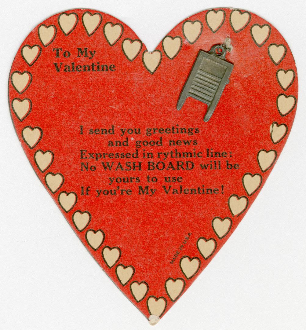 A red heart-shaped card with a rhyming verse written in the middle. Attached to the card is a s ...