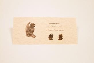 Two small brass pins mounted on a piece of paper which says, "In appreciation of your contribut…