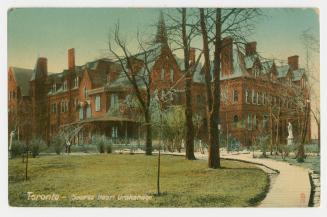 Picture of a large Victorian building with trees in front. 