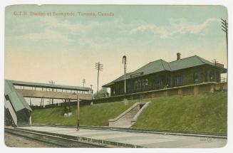 Picture of a railway station with covered walkway down to tracks. 