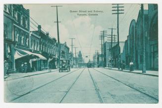 Picture of a street with streetcar line down the middle and buildings on both sides.