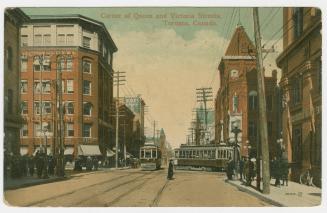 Picture of a busy street intersection with streetcars and one turning. 