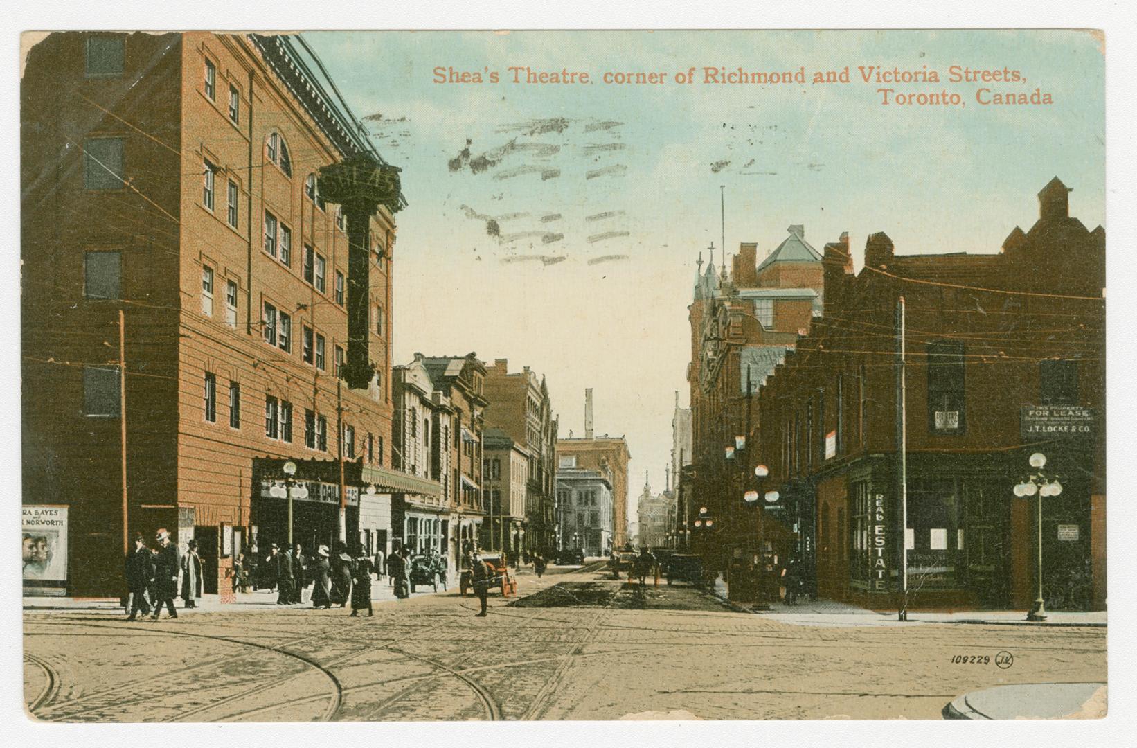 Picture of busy intersection with theatre building on left. 