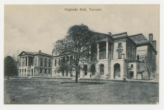 Picture of large buildings facing lawn and trees. 