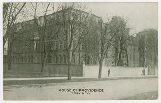 Picture of large building surrounded by tall fence. 