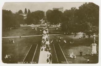 Black and white photograph of many people walking along pathways in a large urban park.