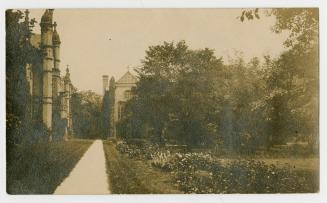 Sepia-toned postcard depicting a photo of the exterior and pathway beside Trinity College. The  ...