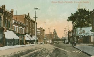 Picture of street scene with buildings on both sides, bridge in the distance. 