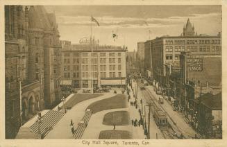 Picture of a street with City Hall and lawns on left and other buildings on right with streetca ...