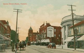 Picture of street with shops, streetcar and horses and wagons. 