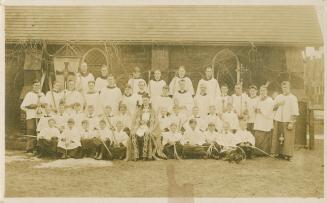 Sepia-toned postcard depicting a group photo of the Minister, church staff, and altar boys/choi ...