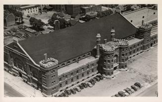 Black and white, aerial photograph of a very large Romanesque Revival, castle-like structure.