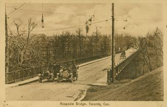 Sepia-toned postcard depicting a photo of the Rosedale Bridge with cars filled with passengers  ...