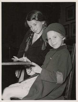 Photo of girls reading at a table in a library.