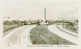 Black and white photograph of a large, monument with lions at it's base in the middle of a six  ...