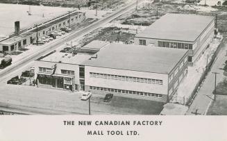 Black and white, aerial photograph of a modern factory complex.