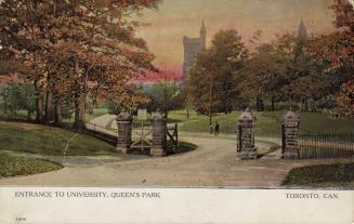 Brick gates on a roadway in front of trees and a large collegiate building with white border al ...