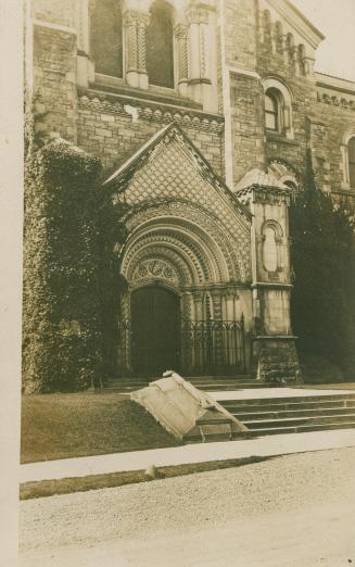 Black and white photograph of an elaborate front door to s stone building.