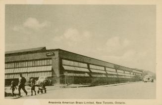 Sepia-toned photo postcard depicting a large warehouse building with many windows. Caption stat ...