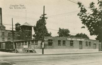 Black/white photo postcard depicting a warehouse building with the sign "Plibrico Jointless Fir ...