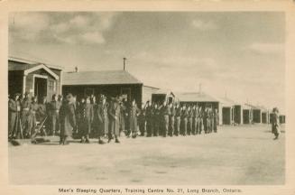 Sepia-toned photo postcard depicting men lined up in front of the sleeping quarters at a Canadi ...